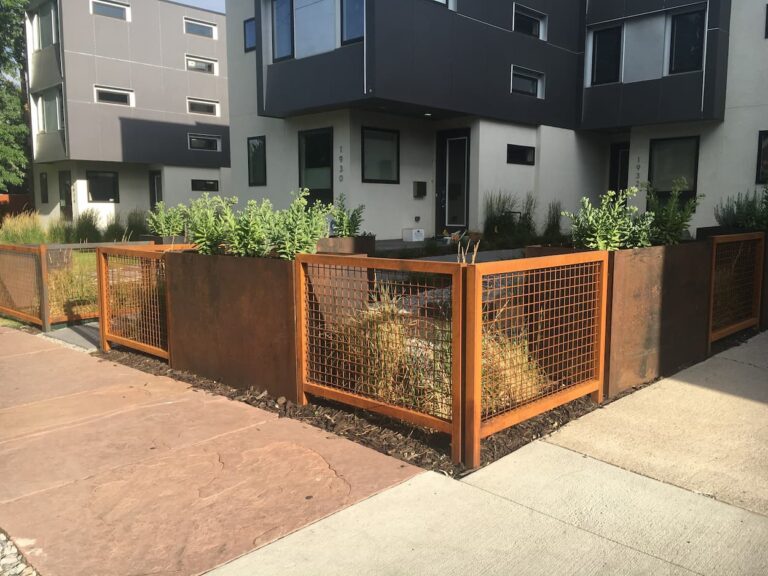 Fence made from steel boxes and mesh panels.