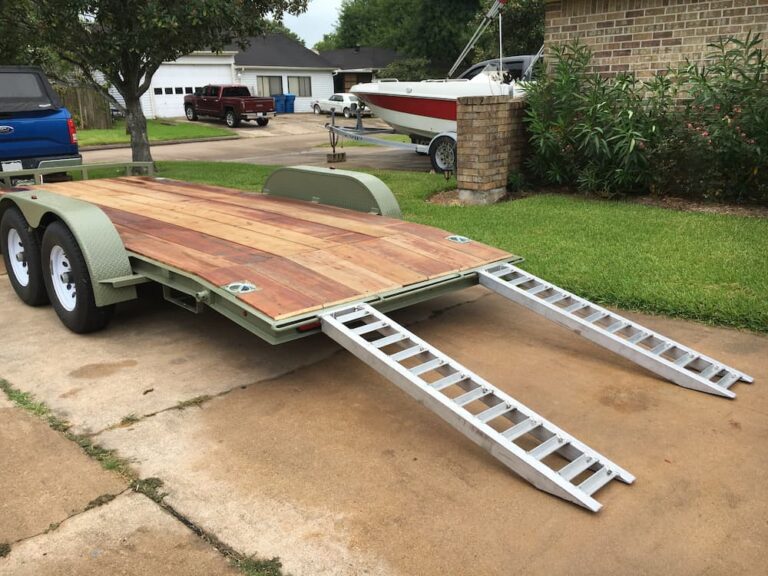 A car trailer with wood deck and aluminum ramps.